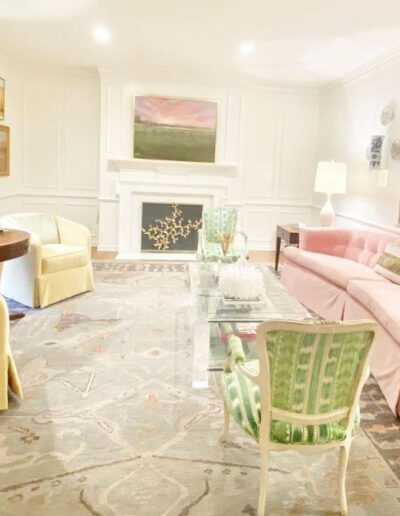 A living room with pink furniture and a mirror.