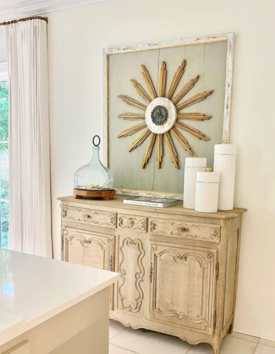 A white dresser with a sunburst in the middle.