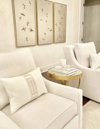 A white living room with a gold table and chairs.