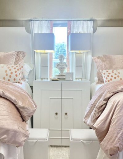 A bedroom with two beds and a white dresser.